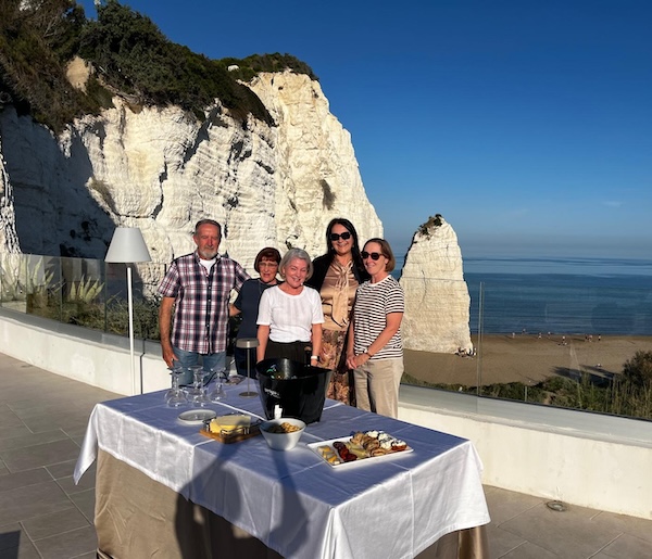 Puglia Tour 2026 guests enjoying an aperitivo on a seaside terrace overlooking white cliffs and the Adriatic coast in Italy